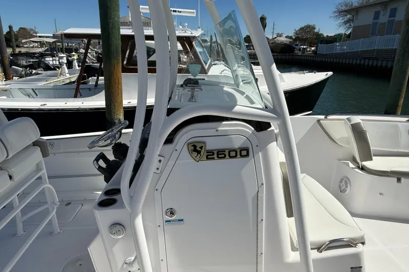 Slide: The Image of 2023 Century 2600 Center Console boat docked, featuring sleek white design and spacious seating. - 11