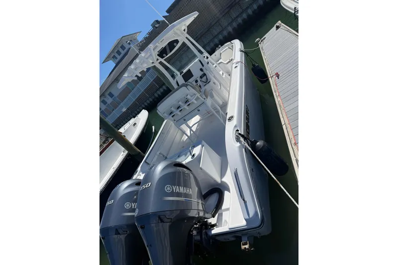 Slide: The Image of 2023 Century 2600 Center Console boat docked with twin Yamaha engines. - 2