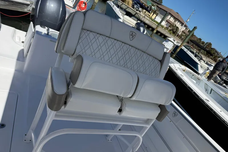 Slide: The Image of 2023 Century 2600 Center Console boat with cushioned seating at a marina. - 3
