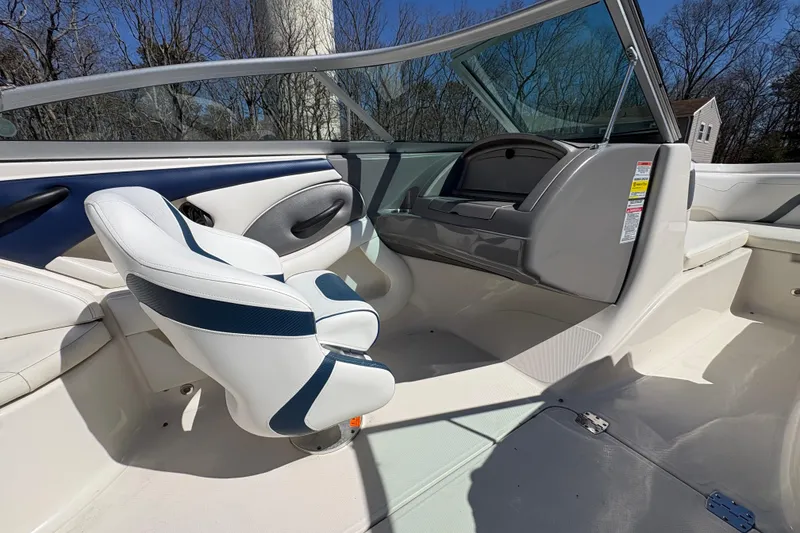 Slide: The Image of 2009 Monterey 214FS boat interior with white and blue seating, open cockpit view. - 12