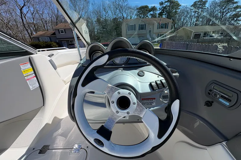 Slide: The Image of Steering wheel and dashboard of a 2009 Monterey 214FS boat, parked in a residential area. - 13