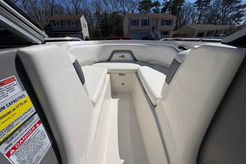 Slide: The Image of 2009 Monterey 214FS boat interior with white seating and safety warning label. - 19