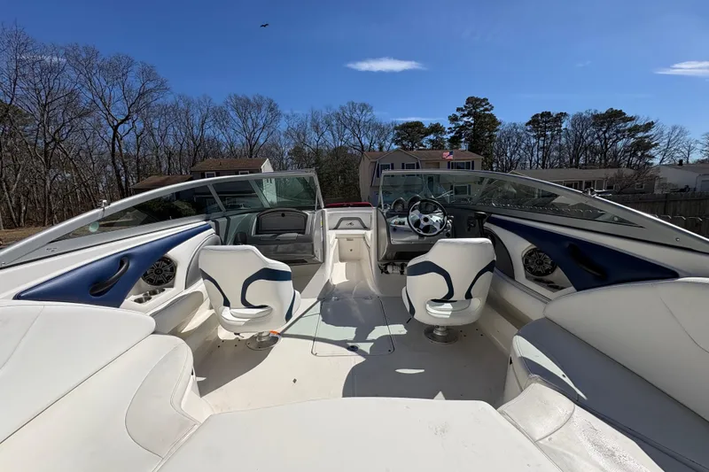 Slide: The Image of 2009 Monterey 214FS boat interior with white and blue seating, steering wheel, and dashboard. - 8