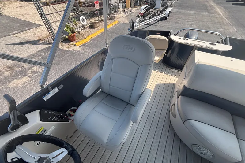 Slide: The Image of 2015 Manitou 20 Oasis Angler boat interior with steering wheel and seating. - 12