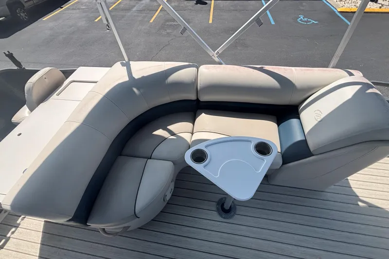 Slide: The Image of 2015 Manitou 20 Oasis Angler boat with beige seating and cupholder table. - 14