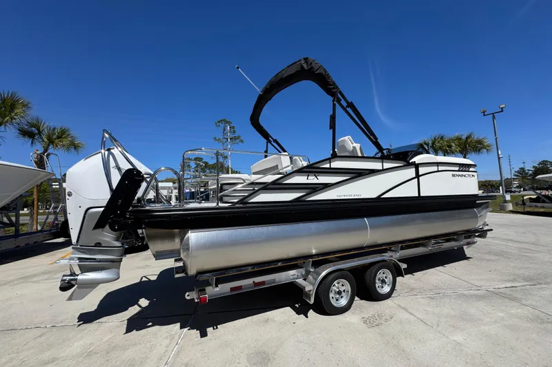 Slide: The Image of 2026 Bennington 22 LXS Swingback pontoon boat on trailer, sunny day. - 10