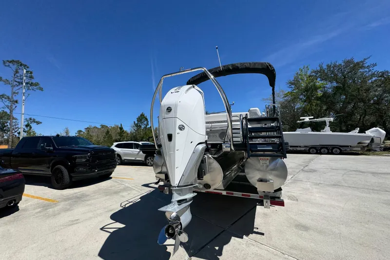 Slide: The Image of 2026 Bennington 22 LXS Swingback pontoon boat with outboard motor in parking lot. - 12