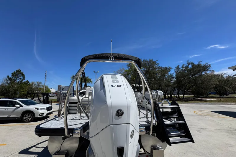 Slide: The Image of 2026 Bennington 22 LXS Swingback boat with V8 engine, parked outdoors under clear blue sky. - 14