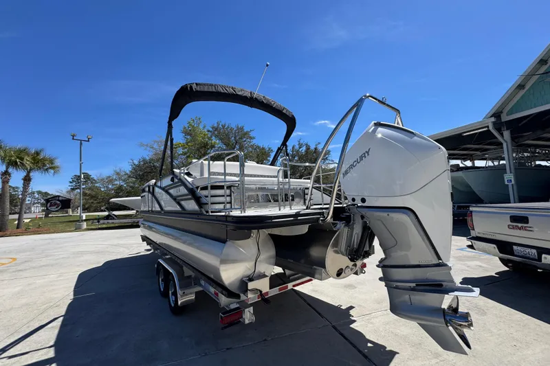 Slide: The Image of 2026 Bennington 22 LXS Swingback pontoon boat with Mercury outboard engine in a sunny marina. - 15