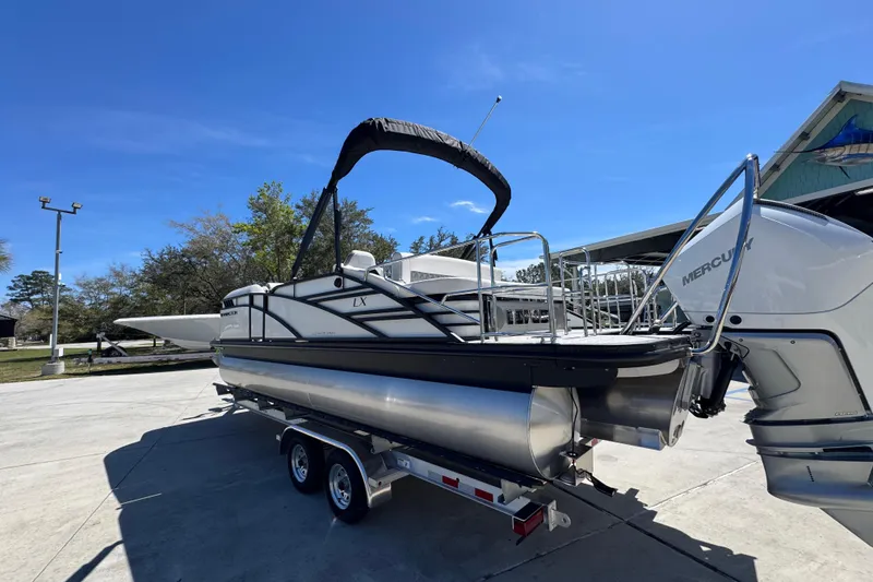 Slide: The Image of 2026 Bennington 22 LXS Swingback pontoon boat on trailer, sunny day. - 16