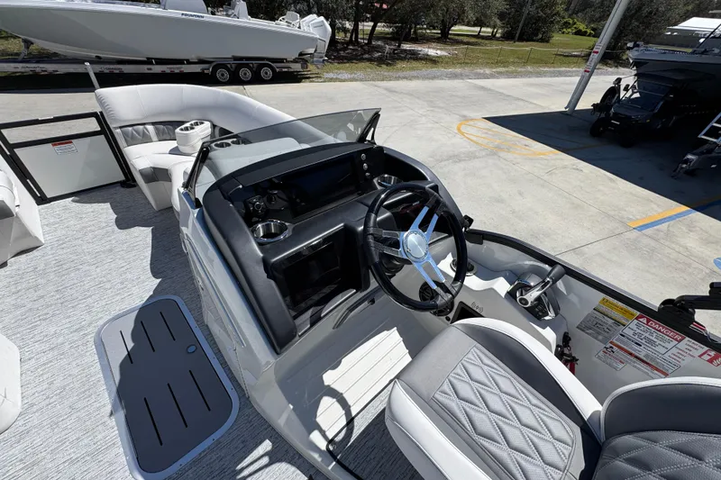Slide: The Image of 2026 Bennington 22 LXS Swingback boat interior with steering wheel and seating area. - 23