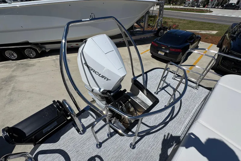 Slide: The Image of 2026 Bennington 22 LXS Swingback with Mercury outboard motor, parked outdoors. - 36