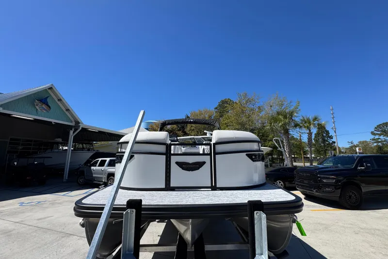 Slide: The Image of 2026 Bennington 22 LXS Swingback pontoon boat on trailer under clear blue sky. - 5