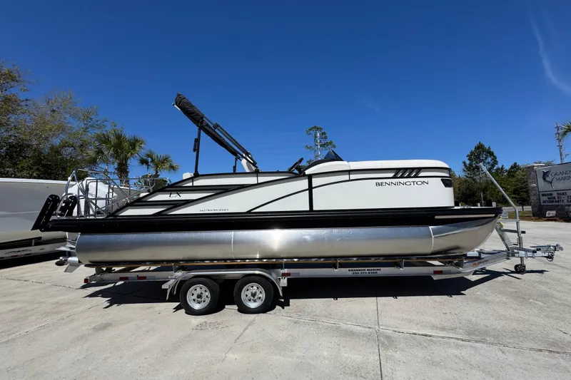 Slide: The Image of 2026 Bennington 22 LXS Swingback pontoon boat on trailer, parked outdoors. - 8