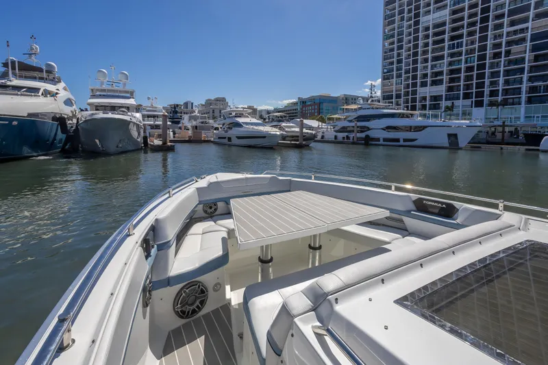 Slide: The Image of 2023 Formula 430 Super Sport Crossover docked in a marina with luxury yachts. - 21