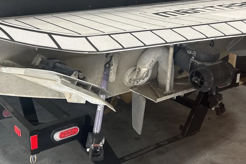 Slide: The Image of 2023 Montara 25 Surf Boss 2.0 CW boat rear view, showcasing propeller and hull details. - 14