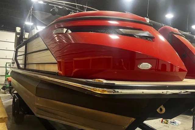 Slide: The Image of 2023 Montara 25 Surf Boss 2.0 CW boat with sleek red exterior in a showroom. - 2