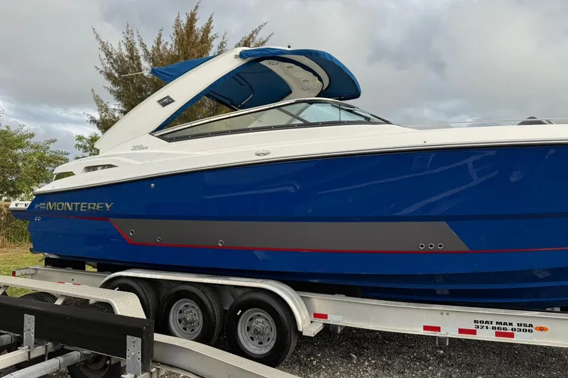 Slide: The Image of 2019 Monterey 328SS Super Sport boat on trailer, blue and white design. - 11