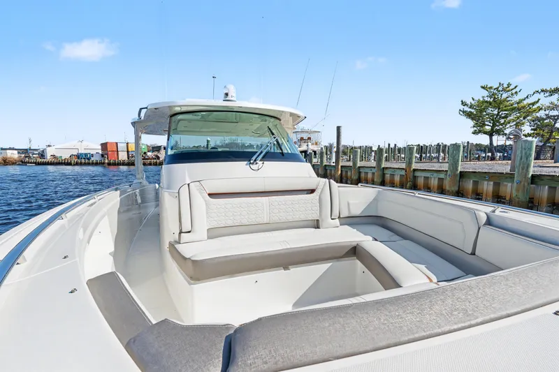 Slide: The Image of 2022 Tiara 38LS luxury boat with spacious seating at a marina dock. - 11