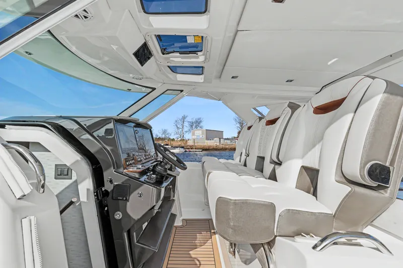 Slide: The Image of Interior view of 2022 Tiara 38LS boat cockpit with modern seating and controls. - 14