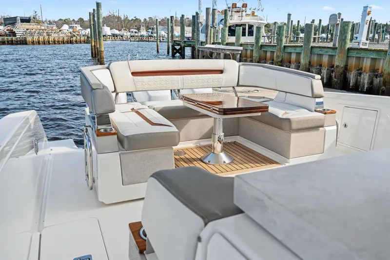 Slide: The Image of Luxurious seating area on a 2022 Tiara 38LS boat, docked at a marina. - 17