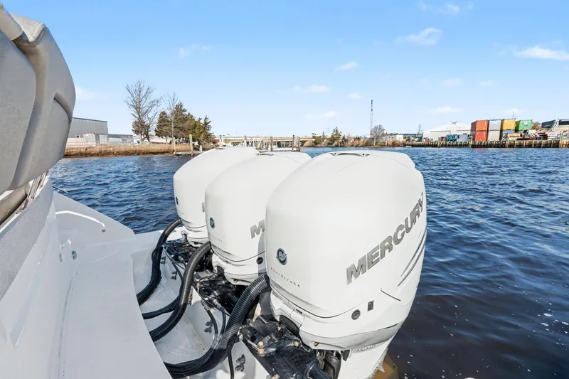 Slide: The Image of 2022 Tiara 38LS boat with triple Mercury outboard engines on a calm waterway. - 19