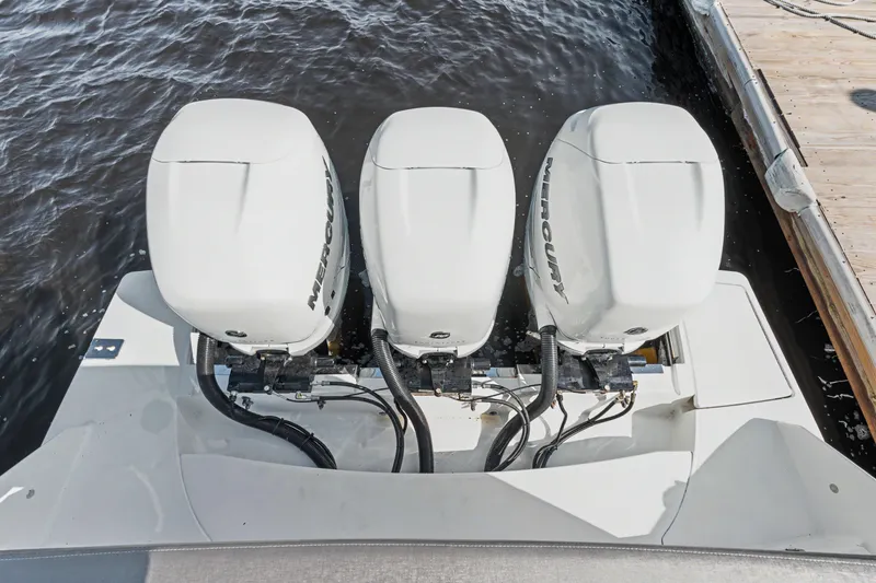 Slide: The Image of Triple Mercury outboard engines on a 2022 Tiara 38LS boat, docked by the water. - 20
