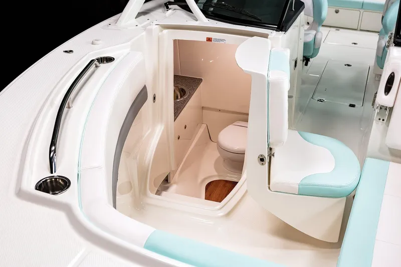 Slide: The Image of Manufacturer Provided Image: 2025 Robalo R317 Dual Console boat interior with compact bathroom and seating. - 19
