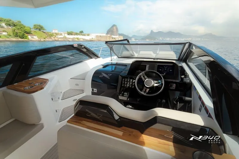 Slide: The Image of 2026 NX Boats NX340 cockpit with modern controls, luxurious seating, and scenic ocean view. - 10