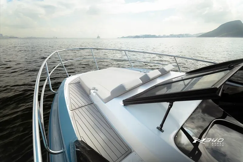 Slide: The Image of 2026 NX Boats NX340 on serene water, showcasing sleek deck design and luxurious features. - 6