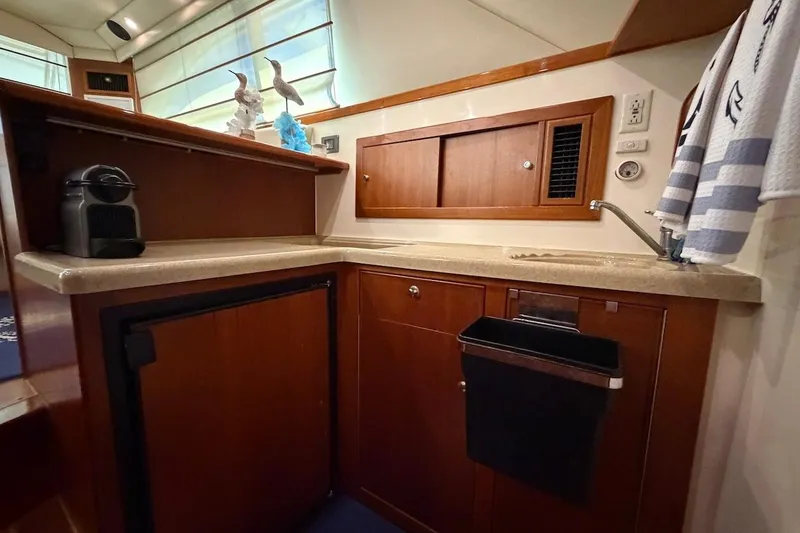 Slide: The Image of Compact kitchen area in a 2005 Riviera 37 Flybridge yacht with wooden cabinetry. - 10