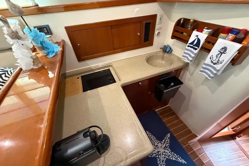 Slide: The Image of Compact kitchen area in a 2005 Riviera 37 Flybridge yacht with nautical decor. - 11