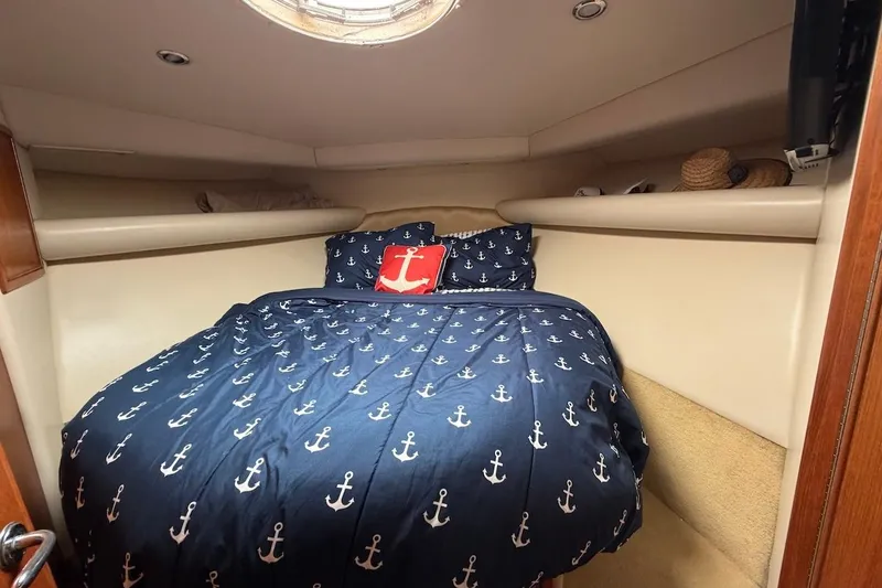 Slide: The Image of Cozy cabin interior of 2005 Riviera 37 Flybridge with nautical-themed bedding. - 13