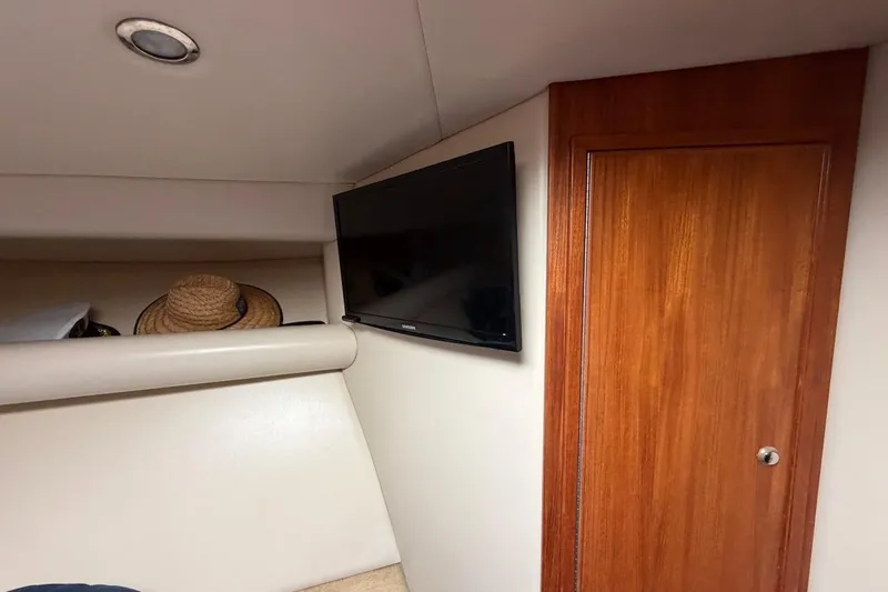 Slide: The Image of Interior of 2005 Riviera 37 Flybridge with TV and wooden door. - 14
