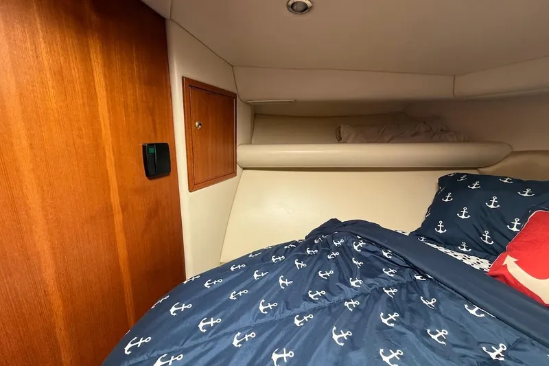 Slide: The Image of Cozy cabin interior of 2005 Riviera 37 Flybridge with nautical-themed bedding. - 15
