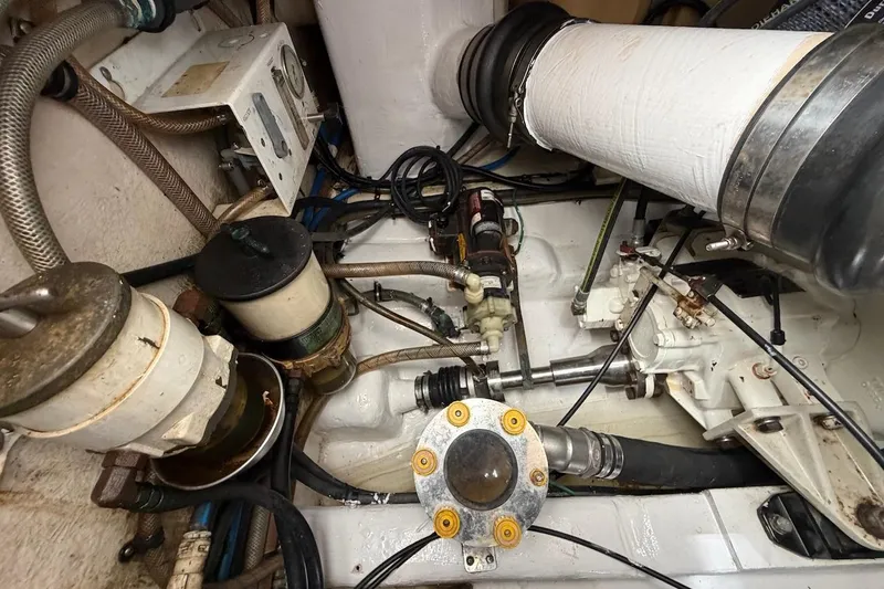 Slide: The Image of Engine room of a 2005 Riviera 37 Flybridge boat, showcasing mechanical components and piping. - 23