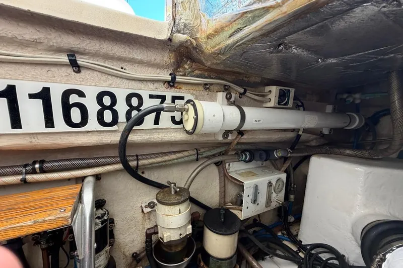 Slide: The Image of Engine room of 2005 Riviera 37 Flybridge with visible pipes and equipment. - 27