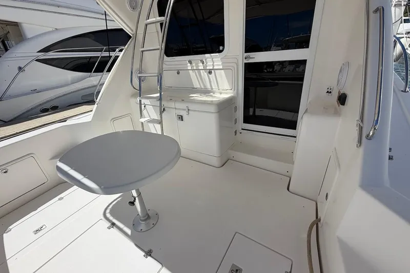 Slide: The Image of 2005 Riviera 37 Flybridge yacht interior with table and ladder, showcasing sleek design. - 5