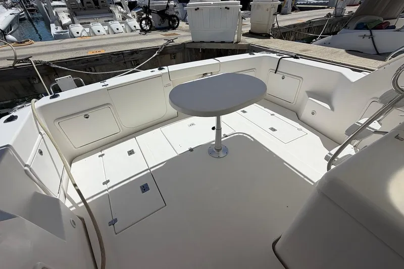 Slide: The Image of 2005 Riviera 37 Flybridge yacht deck with table, docked at marina. - 6