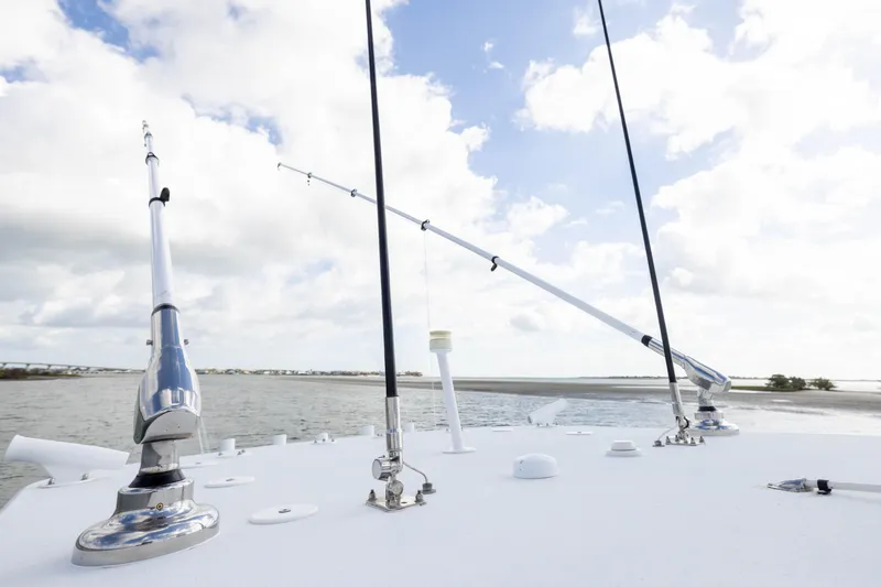 Slide: The Image of 2014 Yellowfin 32 Offshore boat with fishing rods, under a partly cloudy sky. - 14