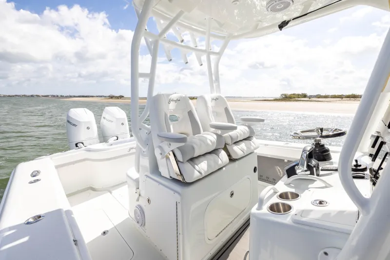 Slide: The Image of 2014 Yellowfin 32 Offshore boat interior with dual Mercury engines, near sandy shoreline. - 15