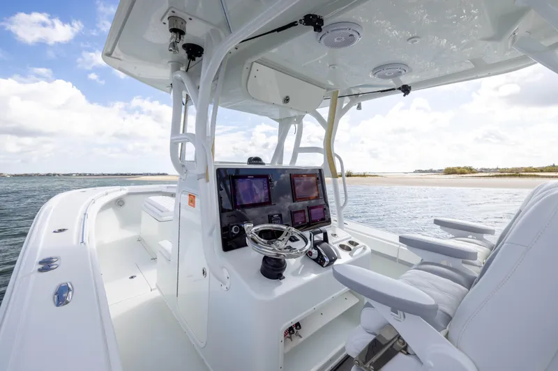 Slide: The Image of 2014 Yellowfin 32 Offshore boat interior with modern navigation equipment and white seating. - 17