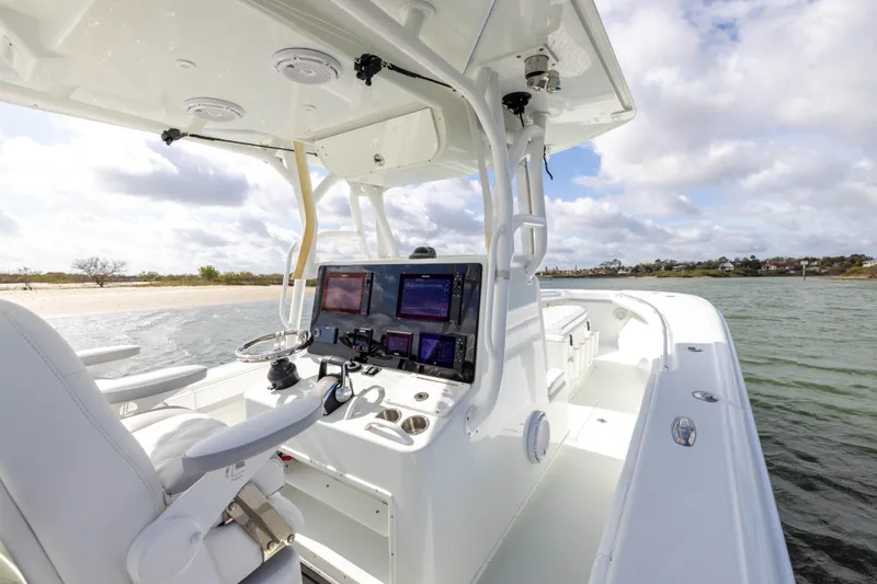 Slide: The Image of 2014 Yellowfin 32 Offshore boat interior with navigation screens, steering wheel, and ocean view. - 18