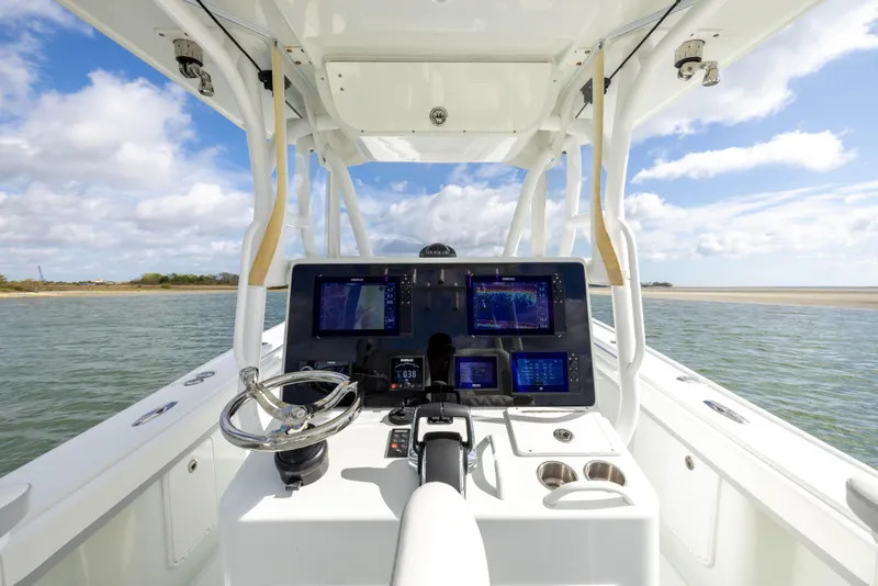 Slide: The Image of 2014 Yellowfin 32 Offshore boat cockpit with navigation screens and steering wheel. - 19