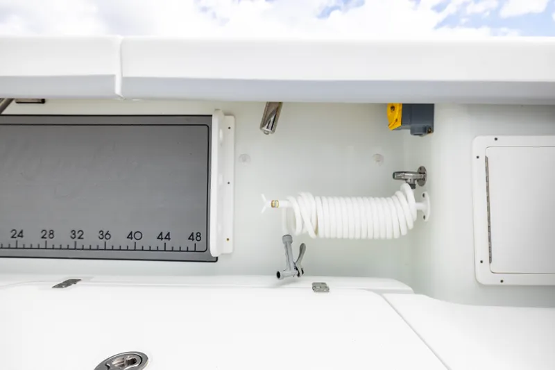 Slide: The Image of 2014 Yellowfin 32 Offshore boat interior with coiled hose and measurement board. - 28