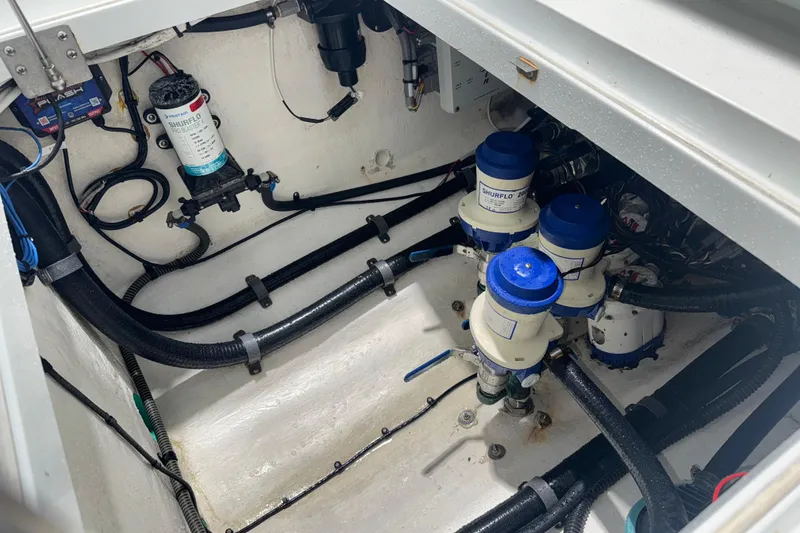 Slide: The Image of Engine compartment of a 2014 Yellowfin 32 Offshore boat, featuring Shurflo pumps and wiring. - 36