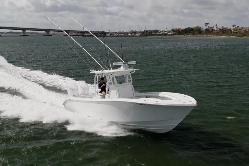 Slide: The Image of 2014 Yellowfin 32 Offshore boat cruising on open water near a bridge. - 4