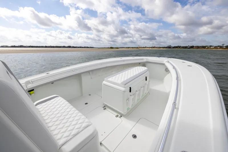 Slide: The Image of 2014 Yellowfin 32 Offshore boat with white seating, on calm waters under a cloudy sky. - 7