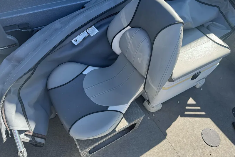 Slide: The Image of Boat seat in a 2019 KingFisher 1625 Falcon, featuring gray upholstery and protective cover. - 10