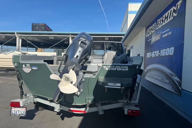 Slide: The Image of 2019 KingFisher 1625 Falcon boat with outboard motor, parked at a marine dealership. - 7